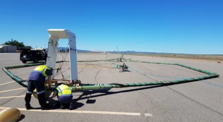 Crew assembling airborne electromagnetic method transmitter loop on runway prior to AEM subsurface survey.