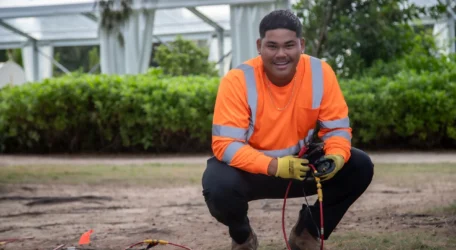 Field technician performing a seismic refraction survey for bedrock depth mapping, placing geophones and connecting cables to collect acoustic velocity data for non-invasive depth-to-bedrock analysis.
