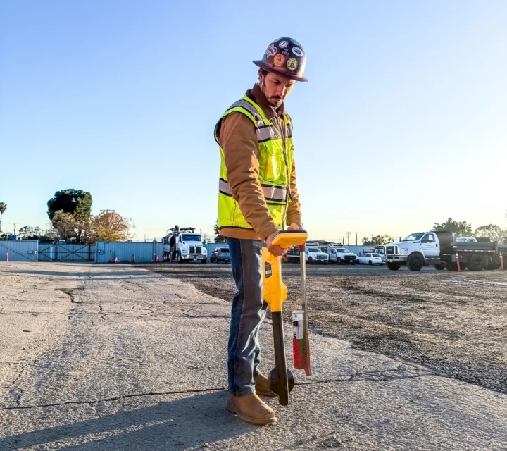 Construction worker using ground penetrating equipment on a construction site.