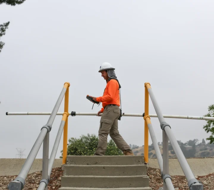 Technician conducting dam leak detection along a concrete structure to evaluate seepage patterns and assess long-term structural integrity.