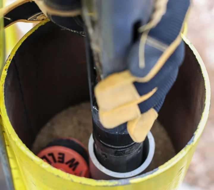 Technician lowers probe into borehole during Downhole geophysical imaging, collecting in-situ measurements to identify fractures, lithology, groundwater conditions, and structural features for geotechnical and environmental characterization.