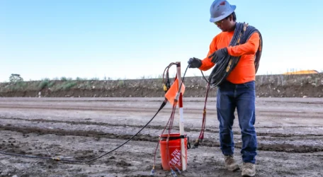 Field technician deploying cables and electrodes for fracture mapping survey to identify subsurface fractures, structural discontinuities, and fluid pathways using non-invasive geophysical methods.