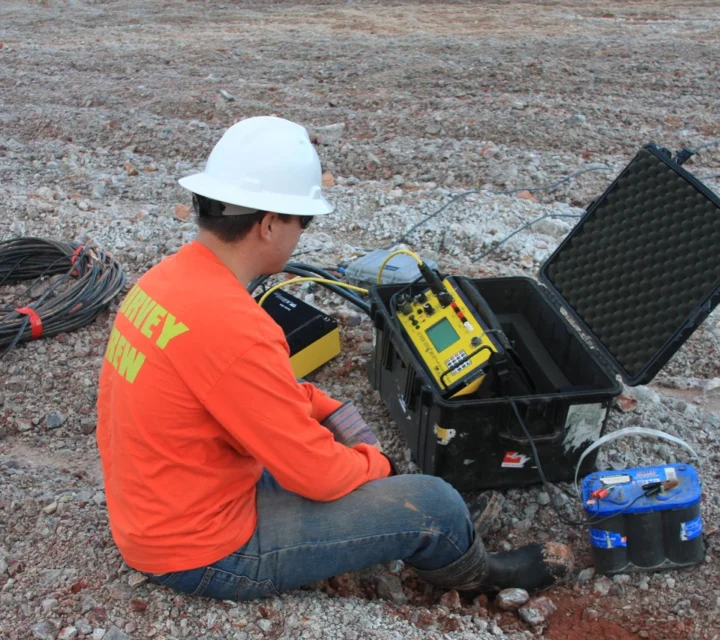 Field technician operating electrical resistivity equipment for geohazard characterization, collecting subsurface data to map voids, weak zones, depth to bedrock, and structural anomalies that influence site stability and geologic risk assessment.