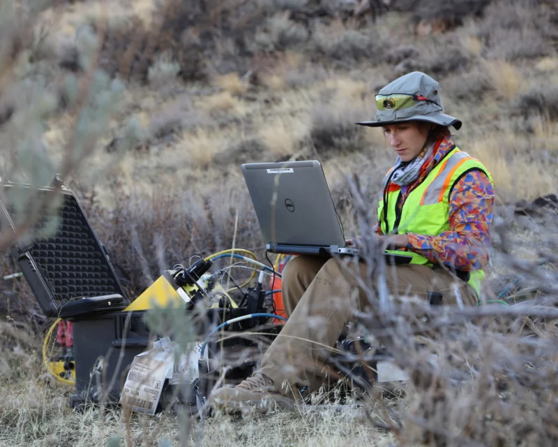 Geophysicist conducting geophysical characterization using field equipment to analyze subsurface structure and material properties non-invasively.