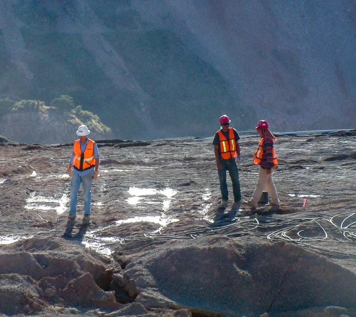 Field crew reviews geophysical mapping layout on mining surface, identifying saturation patterns, internal structure, and flow-influencing features to support operational decisions, risk reduction, and long-term performance of engineered materials.