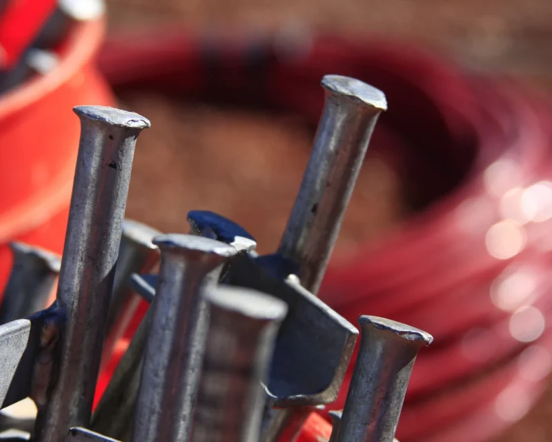 Close-up of field equipment used in geophysical methods, including survey spikes and cable for non-invasive subsurface characterization and data collection supporting geophysical investigations and mapping.