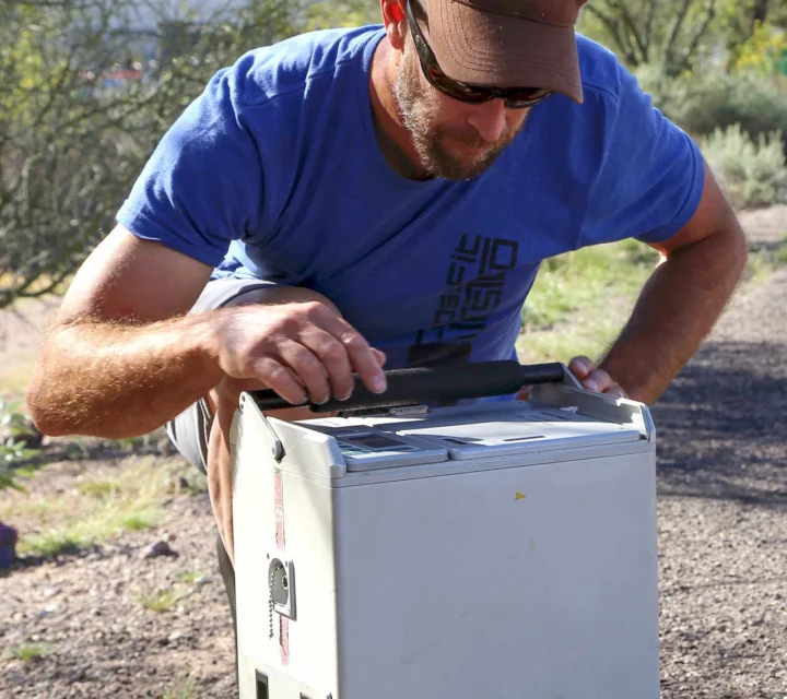 Technician operating portable gravimeter during gravity surveys to measure subtle gravitational field variations and identify subsurface density contrasts supporting regional geologic characterization and investigation planning.