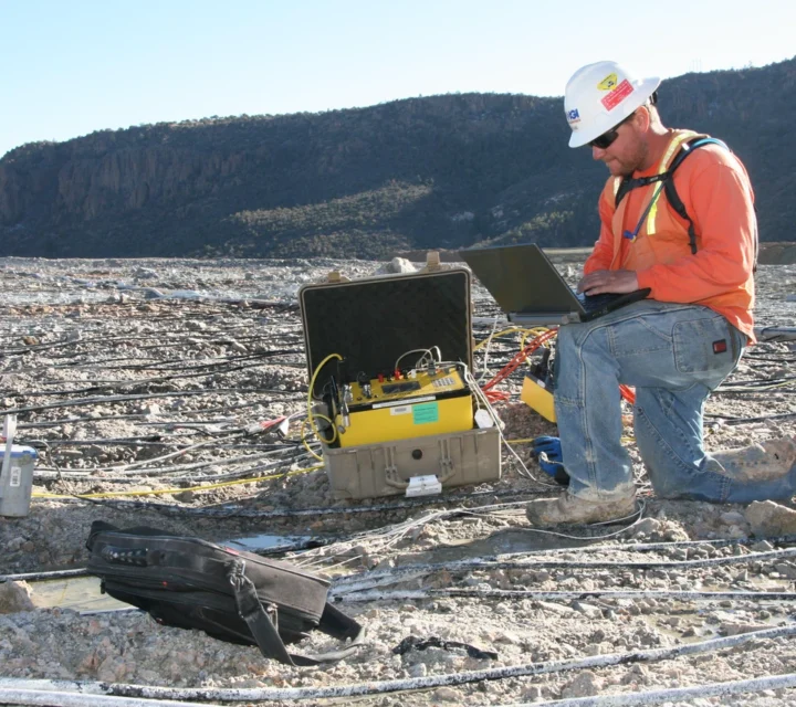 Technician reviews geophysical data on heap leach pad during Heap leach characterization, evaluating moisture distribution, fluid pathways, and wet versus dry zones to support operational optimization and improved recovery performance.
