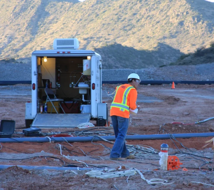 Field technician collects data near mobile lab during Metallurgical monitoring, tracking pressure, flow, temperature, and solution chemistry to assess internal heap conditions and support real-time operational decisions.