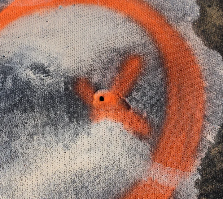 Marked geomembrane liner breach identified during pond leak detection survey to pinpoint exact leak location for targeted repair.