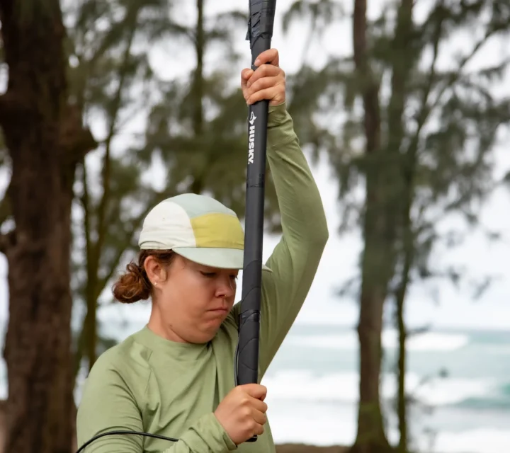 Technician striking ground with sledgehammer to generate seismic energy for seismic reflection survey, producing reflected wave data used to image subsurface layering, structure, and deeper geologic conditions along profile.