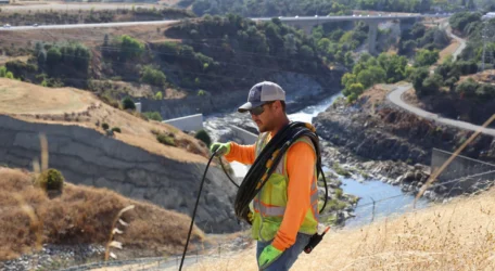 Technician conducting subsurface profiling along a dam embankment to map internal layers, structural variations, and subsurface anomalies using non-intrusive geophysical methods.