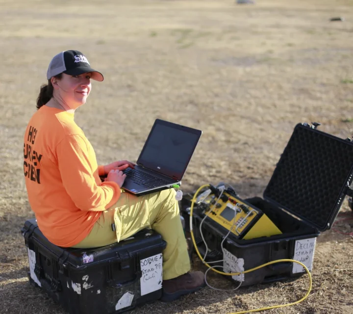 Field geophysicist operating laptop and resistivity equipment during subsurface profiling survey to collect electrical resistivity data for plume mapping, groundwater assessment, and high-resolution subsurface imaging.