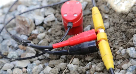 Close-up of geophysical electrodes and cables on rocky ground used for void and karst detection, measuring subsurface resistivity contrasts to identify cavities, fractures, and dissolution features.