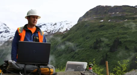 Geophysicist conducting void and karst detection survey in mountainous terrain using surface-based geophysical equipment to identify subsurface cavities, dissolution features, fractured zones, and groundwater flow pathways.